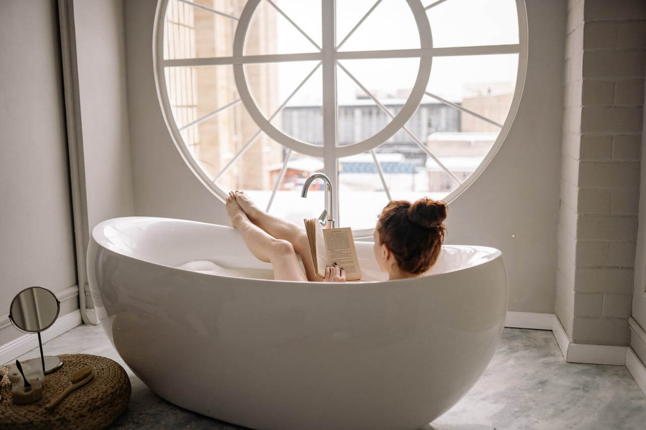 mujer dentro de una bañera disfrutando un baño